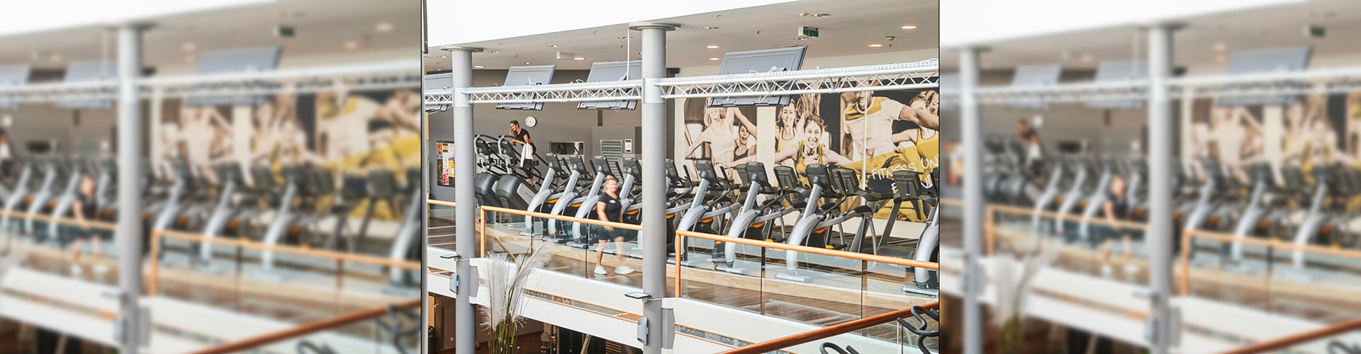 Stepper- und Stairmastergeräte in Reihe gestellt im oberen Bereich des Fitnesstudios in Aachen