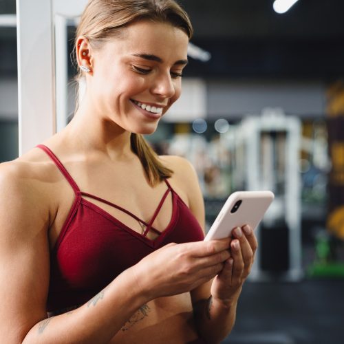 woman-fitness-coach-using-mobile-phone-in-gym.jpg